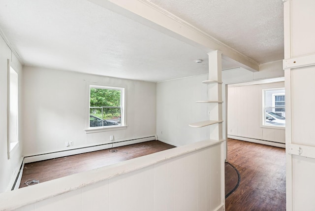 13-15 James St, Auburn, ME 04210 - unfurnished room featuring baseboard heating, a textured ceiling, wood finished floors, and crown molding