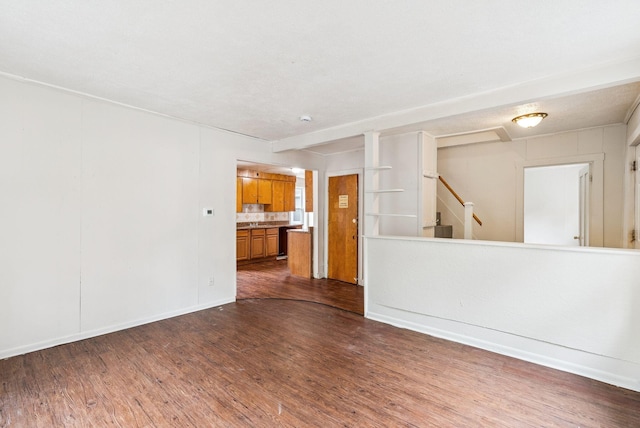 13-15 James St, Auburn, ME 04210 - unfurnished living room featuring dark wood finished floors and stairs