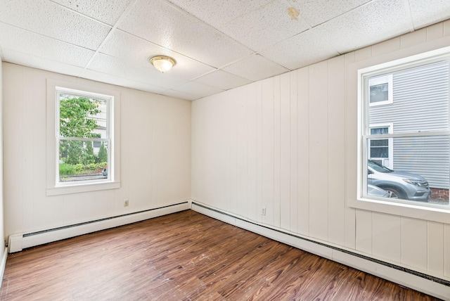 13-15 James St, Auburn, ME 04210 - spare room with wood finished floors, a paneled ceiling, and a baseboard heating unit