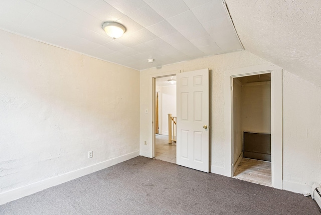 13-15 James St, Auburn, ME 04210 - unfurnished bedroom featuring carpet floors, lofted ceiling, and a baseboard radiator
