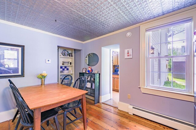 86 High St, Belfast, ME 04915 - dining area with a baseboard heating unit, ornamental molding, light wood-style floors, baseboards, and an ornate ceiling