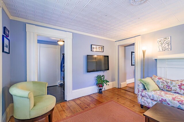 86 High St, Belfast, ME 04915 - living room featuring hardwood / wood-style flooring, baseboards, ornamental molding, and an ornate ceiling