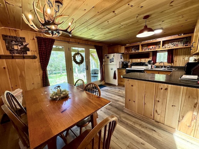 133 Camp Waya-Awi Rd, Rangeley, ME 04970 - dining area with a chandelier, french doors, wood ceiling, light wood-style flooring, and wood walls