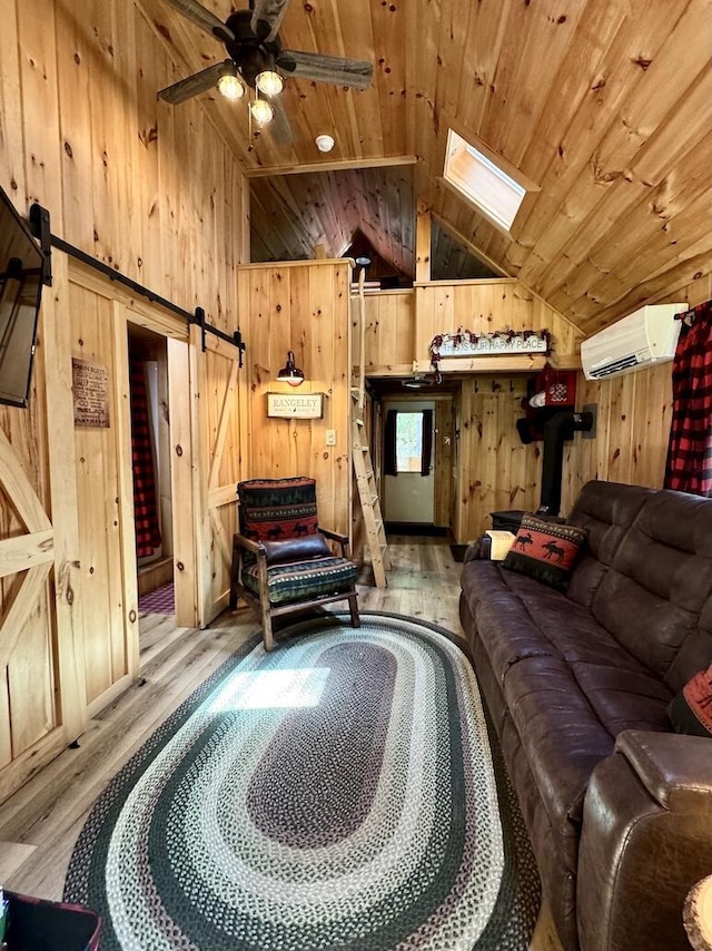 133 Camp Waya-Awi Rd, Rangeley, ME 04970 - living room featuring an AC wall unit, lofted ceiling, wood walls, a barn door, and wood finished floors