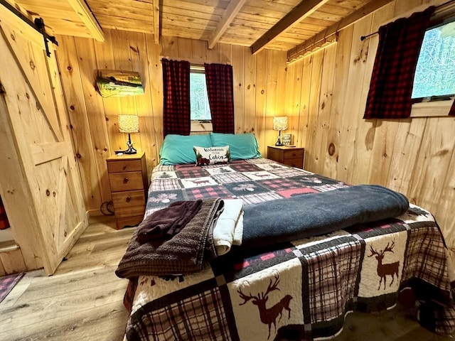 133 Camp Waya-Awi Rd, Rangeley, ME 04970 - bedroom with wooden walls, a wooden ceiling with exposed beams, wood finished floors, and a barn door