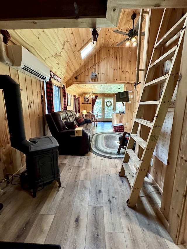 133 Camp Waya-Awi Rd, Rangeley, ME 04970 - living room with a wall unit AC, lofted ceiling, wood-type flooring, a wood stove, and wood walls