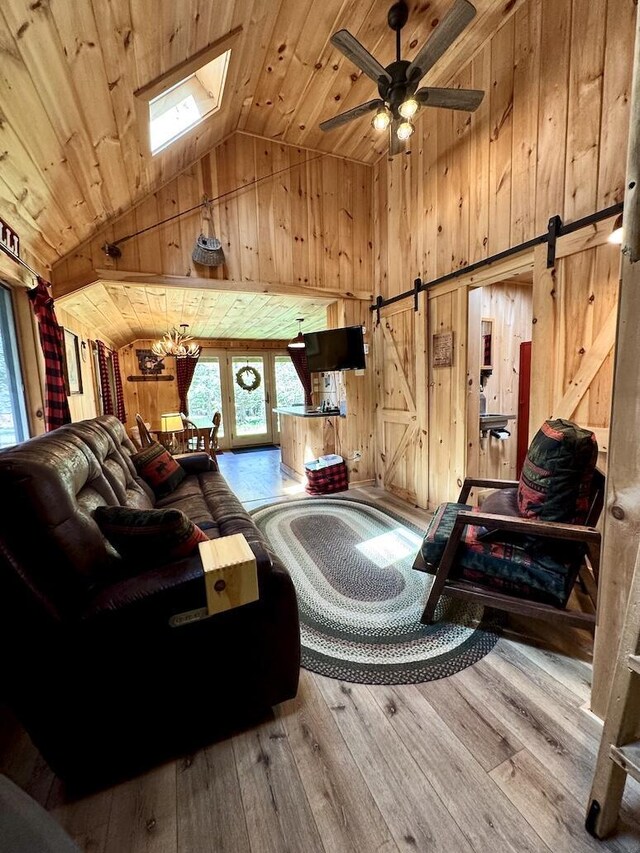 133 Camp Waya-Awi Rd, Rangeley, ME 04970 - living room with wooden walls, a barn door, high vaulted ceiling, wood ceiling, and hardwood / wood-style floors