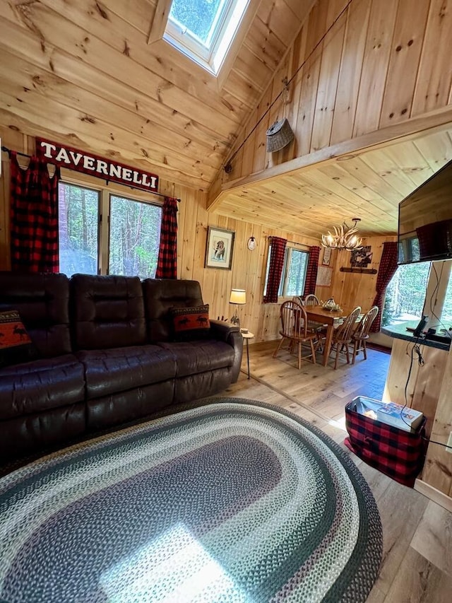 133 Camp Waya-Awi Rd, Rangeley, ME 04970 - living room featuring plenty of natural light, hardwood / wood-style flooring, a skylight, wooden walls, and lofted ceiling