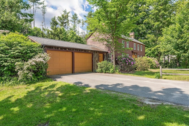 16 Old Village Rd, Winthrop, ME 04364 - view of front of house with asphalt driveway, a front yard, a garage, and a chimney