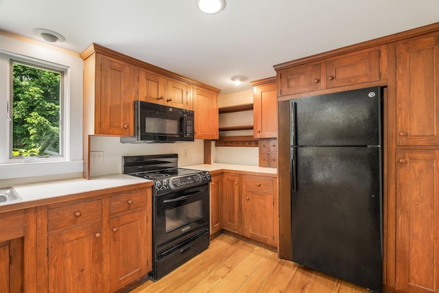 16 Old Village Rd, Winthrop, ME 04364 - kitchen featuring black appliances, light countertops, light wood-type flooring, and brown cabinetry