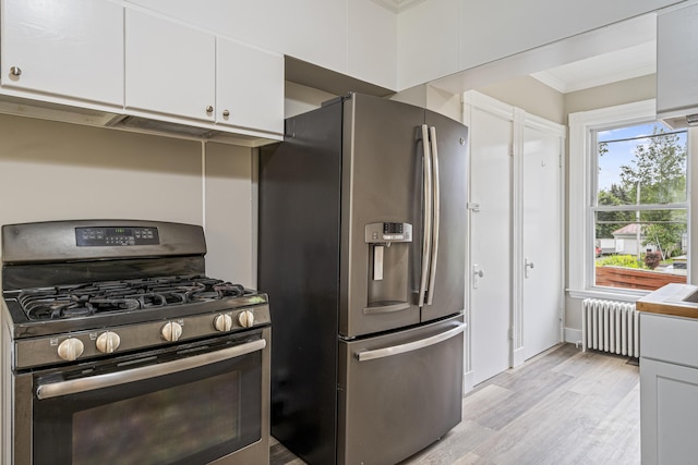 2 Stobie St, Winslow, ME 04901 - kitchen with gas range oven, radiator, stainless steel fridge with ice dispenser, light wood-type flooring, and white cabinetry