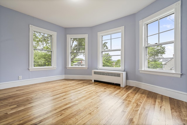 2 Stobie St, Winslow, ME 04901 - unfurnished room featuring radiator, plenty of natural light, and light wood-type flooring