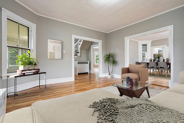 2 Stobie St, Winslow, ME 04901 - living area with ornamental molding, wood finished floors, healthy amount of natural light, radiator heating unit, and stairs