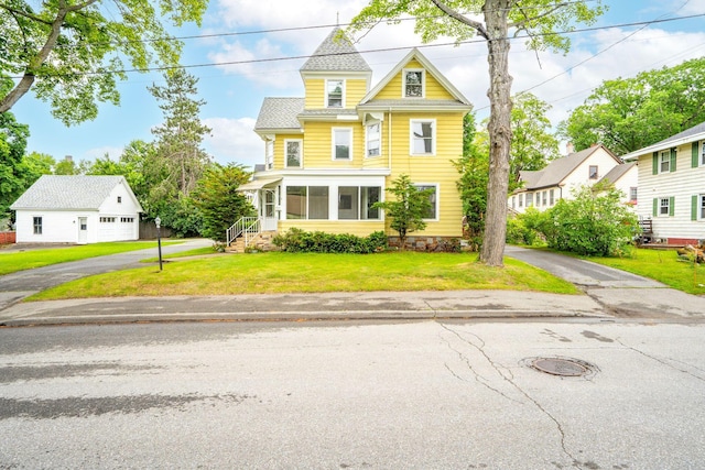 2 Stobie St, Winslow, ME 04901 - victorian-style house with an outbuilding, a front yard, a garage, and asphalt driveway