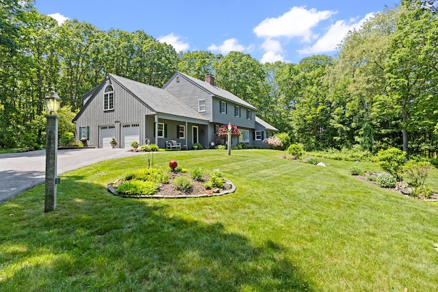 6 Hackmatack Dr, Scarborough, ME 04074 - view of front of house with asphalt driveway, a chimney, a front lawn, and a garage