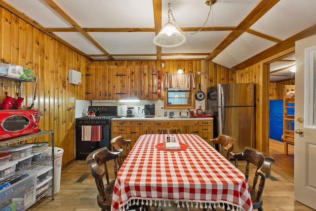 60 Watson Hill Rd, Limerick, ME 04048 - kitchen with freestanding refrigerator, gas range oven, wood walls, light wood-style floors, and light countertops