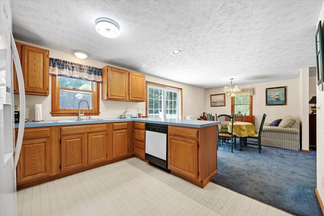 52 Douglas Ave, Saco, ME 04072 - kitchen featuring white appliances, a peninsula, brown cabinetry, light countertops, and a chandelier