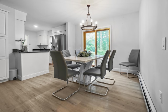282 Back Narrows Rd, Boothbay, ME 04537 - dining area with baseboard heating, light wood-style floors, and a chandelier