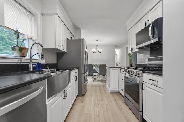 282 Back Narrows Rd, Boothbay, ME 04537 - kitchen featuring stainless steel appliances, dark countertops, a chandelier, white cabinetry, and light wood-style flooring