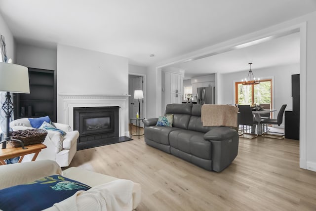282 Back Narrows Rd, Boothbay, ME 04537 - living area featuring light wood-style flooring, a chandelier, and a fireplace