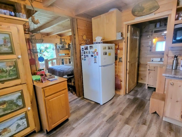 40 Griffin Mountain Rd, New Vineyard, ME 04956 - kitchen featuring freestanding refrigerator, wooden walls, wood finished floors, plenty of natural light, and light countertops