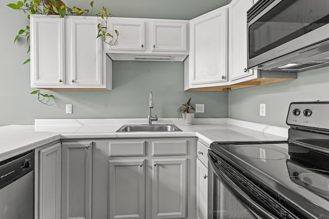 30 Lincoln St Unit 109, Westbrook, ME 04092 - kitchen with appliances with stainless steel finishes, a sink, light countertops, and white cabinetry