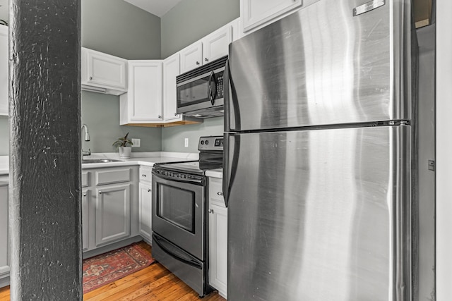 30 Lincoln St Unit 109, Westbrook, ME 04092 - kitchen with appliances with stainless steel finishes, a sink, light wood finished floors, light countertops, and white cabinetry