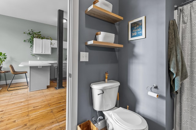 30 Lincoln St Unit 109, Westbrook, ME 04092 - full bathroom with wood finished floors, toilet, baseboards, and a shower with shower curtain