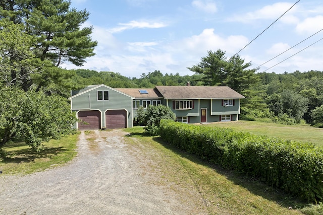 474 Center St, Nobleboro, ME 04555 - view of front of home with dirt driveway, a front lawn, a wooded view, and a garage