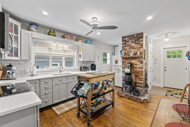 223 Centre St, Bath, ME 04530 - kitchen with freestanding refrigerator, backsplash, light wood-type flooring, a ceiling fan, and recessed lighting