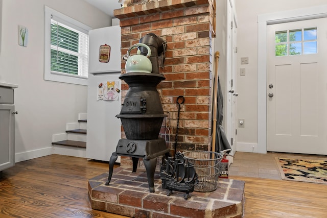 223 Centre St, Bath, ME 04530 - entrance foyer featuring wood finished floors, a wood stove, and stairs