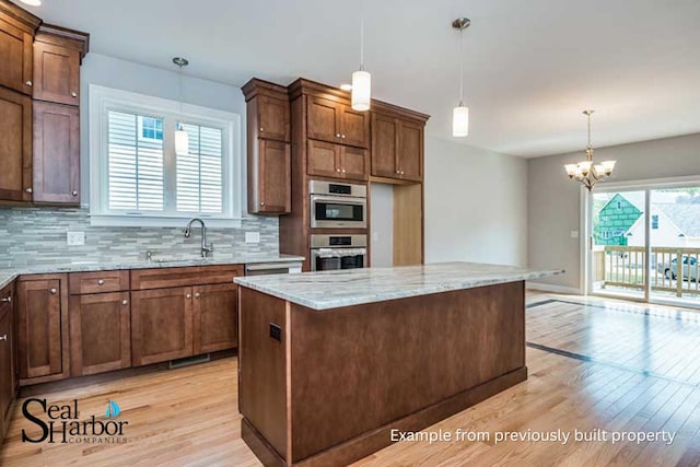 11 Clam Ln Unit B, Wells, ME 04090 - kitchen featuring stainless steel oven, light wood-style flooring, light stone counters, and tasteful backsplash