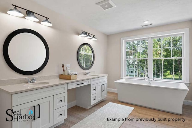 11 Clam Ln Unit B, Wells, ME 04090 - full bathroom featuring double vanity, wood finished floors, and a soaking tub