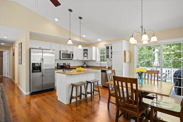 22 Fox Run Rd, Gray, ME 04039 - kitchen featuring stainless steel appliances, decorative backsplash, glass insert cabinets, lofted ceiling, and a center island