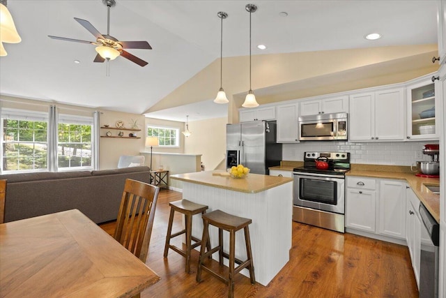 22 Fox Run Rd, Gray, ME 04039 - kitchen featuring appliances with stainless steel finishes, vaulted ceiling, a kitchen island, open floor plan, and white cabinetry
