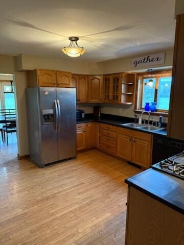 396 E Ridge Rd, Mars Hill, ME 04758 - kitchen with stainless steel fridge, light wood-style flooring, brown cabinetry, dark countertops, and glass insert cabinets
