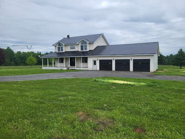 396 E Ridge Rd, Mars Hill, ME 04758 - view of front of home with a porch, driveway, a garage, a front yard, and a metal roof