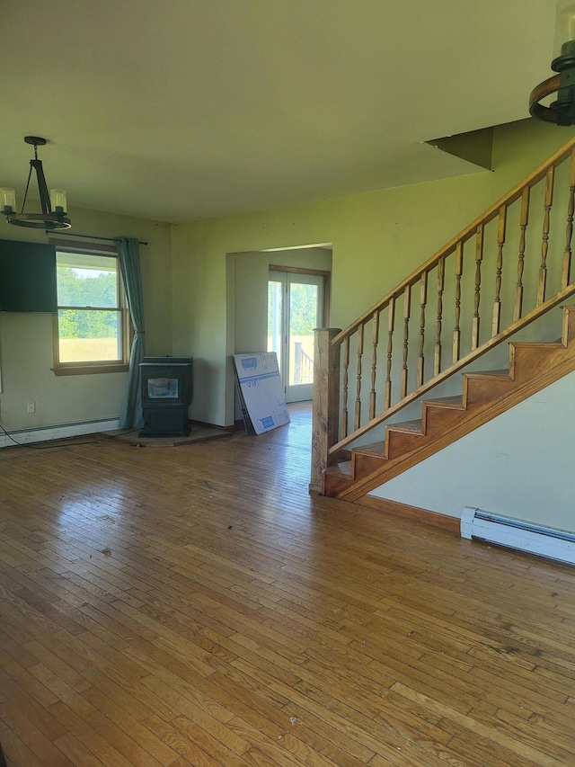 396 E Ridge Rd, Mars Hill, ME 04758 - unfurnished living room featuring healthy amount of natural light, wood-type flooring, a wood stove, and stairs
