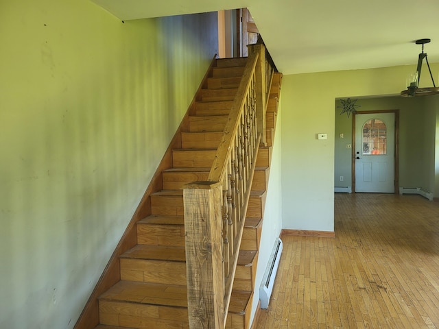 396 E Ridge Rd, Mars Hill, ME 04758 - staircase featuring a baseboard heating unit, a baseboard radiator, and wood finished floors
