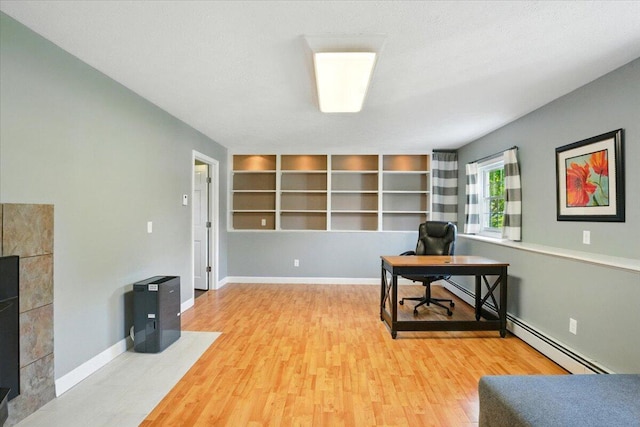 4 Hawthorne Pl, Lewiston, ME 04240 - home office with wood finished floors, a baseboard radiator, and a tiled fireplace
