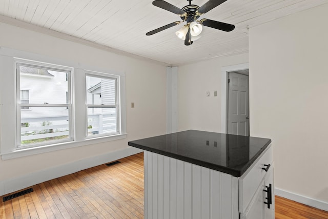 200 Main St, Freeport, ME 04032 - kitchen with dark countertops, light wood-style flooring, ceiling fan, white cabinets, and wood ceiling