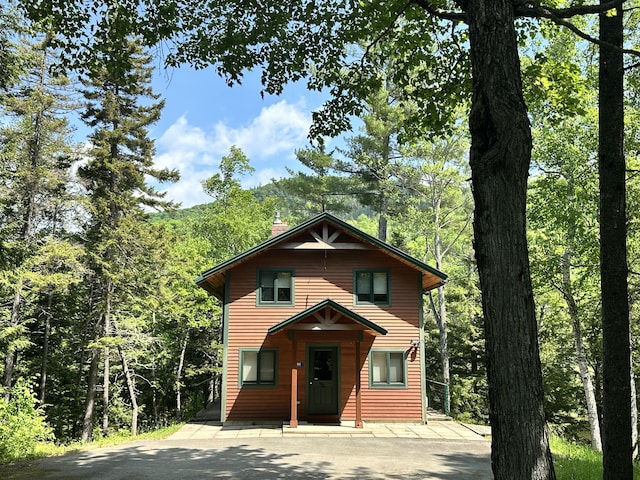 1006 Carrabassett Dr, Carrabassett Valley, ME 04947 - rustic home featuring a chimney and a forest view