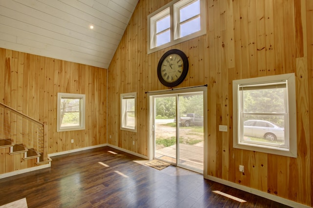 6 Meadow Ln, Sabattus, ME 04280 - unfurnished living room featuring high vaulted ceiling, wood walls, dark wood-style flooring, and stairs