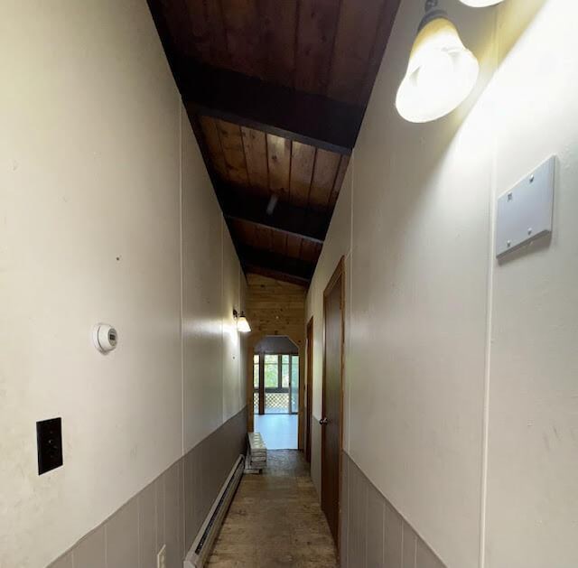 235 S Reynolds Rd, Winslow, ME 04901 - hallway with wooden ceiling, a baseboard heating unit, arched walkways, and wood walls