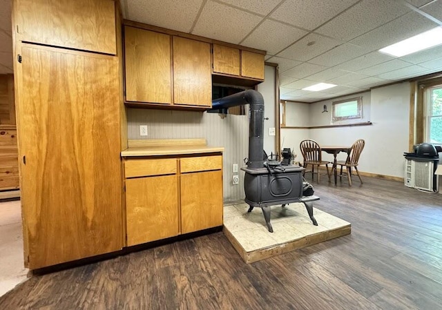 235 S Reynolds Rd, Winslow, ME 04901 - kitchen featuring a wood stove, dark wood-style floors, light countertops, and brown cabinetry