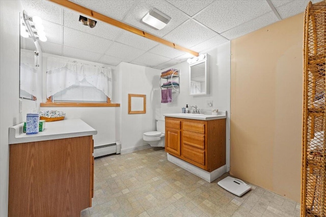 182 Myrtle St, Westbrook, ME 04092 - bathroom with a baseboard heating unit, tile patterned floors, a paneled ceiling, and vanity