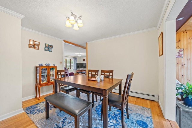 182 Myrtle St, Westbrook, ME 04092 - dining space with ornamental molding, light wood-style floors, a textured ceiling, a baseboard radiator, and a chandelier