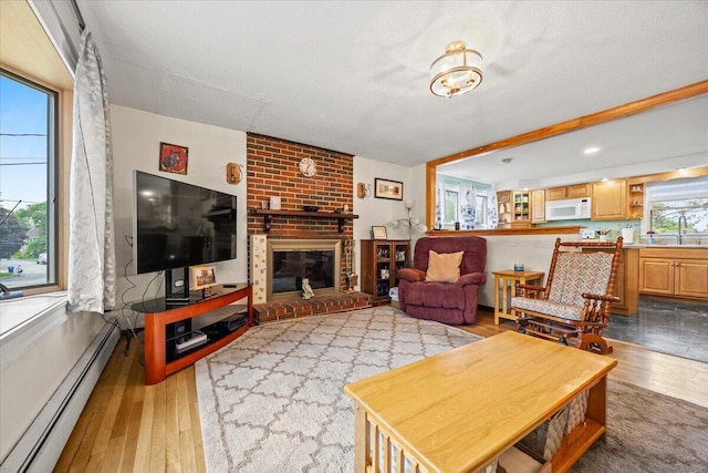 182 Myrtle St, Westbrook, ME 04092 - living area with a baseboard heating unit, hardwood / wood-style flooring, and a fireplace