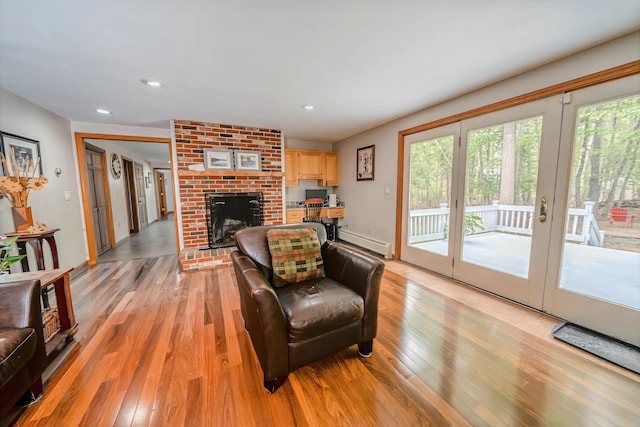 82 Eaton Ridge Dr, Holden, ME 04429 - living room featuring baseboard heating, healthy amount of natural light, light wood-type flooring, a brick fireplace, and recessed lighting