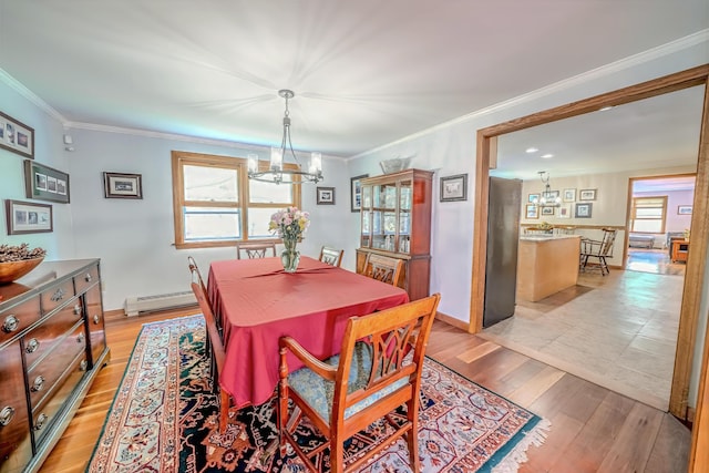 82 Eaton Ridge Dr, Holden, ME 04429 - dining area with a chandelier, a baseboard radiator, light wood-type flooring, and ornamental molding